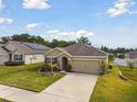 Charming single Gathering home features a well-manicured lawn and a two car garage at 6882 Silverado Ranch Blvd, Zephyrhills, FL 33541