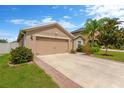 Home exterior shows a two car garage, concrete driveway, and manicured lawn at 8529 Hunters Fork Loop, Ruskin, FL 33573