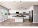 Modern kitchen with white cabinetry, stainless steel appliances, and a center island with black countertops at 8555 112Th St # 209, Seminole, FL 33772