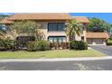 Two-story condo boasting a tile roof, an upper deck, and lush landscaping at 10216 Seminole Island Dr, Largo, FL 33773