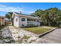 Inviting single-story home showcasing neat landscaping and a gravel driveway at 104 W South Ave, Tampa, FL 33603