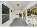 Covered front porch with white railings and a brick floor, offering a cozy outdoor space at 104 W South Ave, Tampa, FL 33603