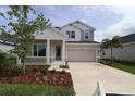 Inviting two-story home featuring stone accents, a two-car garage, and beautifully landscaped front yard at 11884 Richmond Trl, Parrish, FL 34219