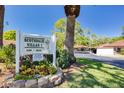 Landscaped Scottsdale Villas I sign with colorful flowers, mature trees and a well-maintained community entrance at 1201 Montrose Pl, Dunedin, FL 34698