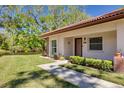 Charming villa exterior with lush landscaping and a view of the pond at 1201 Montrose Pl, Dunedin, FL 34698