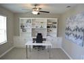 Bright office space with built-in shelving, sleek white desk, and contemporary decor provides an ideal work-from-home environment at 12957 Wildflower Meadow Dr, Riverview, FL 33579