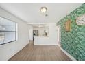 Bright living space featuring hardwood floors, an adjacent modern kitchen, and a stylish accent wall at 1300 37Th S St, St Petersburg, FL 33711