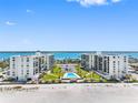 Stunning beachfront condo buildings featuring well-maintained grounds, palm trees, and a shared outdoor swimming pool at 1430 Gulf Blvd # 309, Clearwater Beach, FL 33767