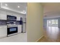 Modern kitchen boasts stainless steel appliances, subway tile backsplash, white cabinets, and easy access to the living area at 1466 Normandy Park Dr # 4, Clearwater, FL 33756