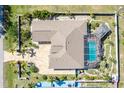 Aerial view of a home featuring a screened-in pool, fenced yard, patio, and well-maintained landscaping at 151 Harrisburg St, Port Charlotte, FL 33954