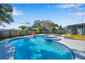 Sparkling pool with attached hot tub, pink flamingo float, and outdoor lounge area offer a perfect backyard oasis at 1571 Belleair Rd, Clearwater, FL 33756
