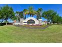 Talavera community entrance featuring colorful flowers and a well-manicured lawn under a bright blue sky at 18715 Alfaro Loop Ct, Spring Hill, FL 34610
