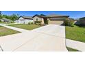 Beautiful home with a spacious driveway, manicured lawn, and a charming exterior at 18715 Alfaro Loop Ct, Spring Hill, FL 34610