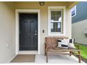 Close-up of the front door with a bench, a window, and elegant detailing at 22229 Storybook Cabin Way, Land O Lakes, FL 34637