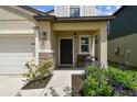 Inviting covered front porch with bench seating and manicured flower beds at 22229 Storybook Cabin Way, Land O Lakes, FL 34637