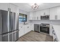 Bright kitchen with stainless steel appliances, white cabinets, and a window view at 2489 Oakleaf Ln # 21C, Clearwater, FL 33763