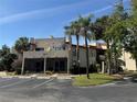 Attractive multi-story building featuring stucco walls, terracotta roofing, spiral staircases, and lush landscaping at 2571 Cyprus Dr # 1-102, Palm Harbor, FL 34684