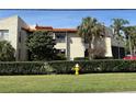 Lovely multi-story building boasting beautiful landscaping, terracotta roof, and a neatly trimmed hedge in the front at 2571 Cyprus Dr # 1-102, Palm Harbor, FL 34684