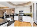 Modern kitchen with stainless steel appliances, white cabinetry, and sleek black countertops at 2837 Bayshore Trails Dr, Tampa, FL 33611