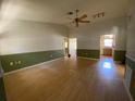 Spacious living room with hardwood floors, a ceiling fan, neutral colors, and baseboards throughout at 3257 Bluestone Ave, Spring Hill, FL 34609