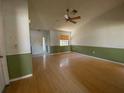 Spacious living room with hardwood floors, a ceiling fan, neutral colors, and baseboards throughout at 3257 Bluestone Ave, Spring Hill, FL 34609