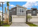 New home showcasing a two-car garage, contemporary design, and well-manicured landscaping at 3467 Timber Crossing Ave, Brandon, FL 33511