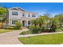 Elegant two-story house featuring a beautiful white exterior, arched porch, and meticulously landscaped front yard at 47 Martinique Ave, Tampa, FL 33606