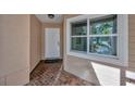Welcoming front entrance with brick flooring, a white door, and a view of the sunny exterior at 5245 Lochmead Ter, Zephyrhills, FL 33541