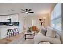 Cozy living room features modern decor, a ceiling fan, and a seamless transition to the adjacent updated kitchen at 5444 70Th N Ln, St Petersburg, FL 33709
