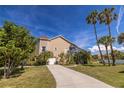 Side view of home showing a large yard, mature landscaping, and attached garage at 7345 Brightwaters Ct, New Port Richey, FL 34652