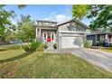 Charming home featuring well-manicured lawn, paved driveway, and inviting red front door at 7417 S Morton St, Tampa, FL 33616