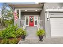 Inviting front porch with a red door, an American flag, and potted plants at 7417 S Morton St, Tampa, FL 33616