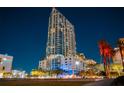Exterior night view of a modern high-rise with palm trees and architectural lighting at 777 N Ashley Dr # 2610, Tampa, FL 33602