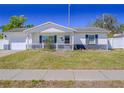 Inviting single-story home with a tidy front yard, white picket fence, and an attached one-car garage at 7827 Crosier Ct, New Port Richey, FL 34653
