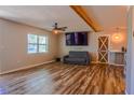 Cozy living room with hardwood floors, a ceiling fan, mounted TV, and a sliding barn door feature at 7827 Crosier Ct, New Port Richey, FL 34653