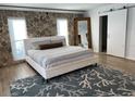 Bedroom with a stone accent wall, white linens and an ocean themed rug at 7912 Causeway S Blvd, St Petersburg, FL 33707