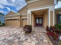 Charming home featuring a three-car garage and a beautiful brick walkway leading to the front entrance at 8578 Gibbons Grove Loop, Land O Lakes, FL 34637