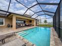 Relaxing screened-in pool area with outdoor seating and a view of the backyard at 8578 Gibbons Grove Loop, Land O Lakes, FL 34637