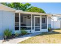 Charming screened front porch with a ceiling fan and freshly landscaped garden at 8766 91St St, Seminole, FL 33777