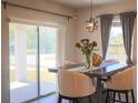 Cozy dining area with natural light, a view to the patio, contemporary lighting, and comfortable seating at 901 Golden Shiner Ave, Ruskin, FL 33570