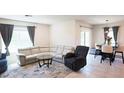 Inviting living room featuring a large comfortable sectional, area rug, and a dining area with stylish pendant lighting at 901 Golden Shiner Ave, Ruskin, FL 33570