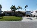 Well-maintained home with lush front lawn and convenient RV parking in the driveway, under a clear blue sky at 187 175Th Terrace E Dr, Redington Shores, FL 33708