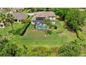 Beautiful aerial view of a green backyard, a sparkling swimming pool with a screen enclosure and trees at 21654 Draycott Way, Land O Lakes, FL 34637