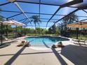 Outdoor screened pool with patio, lounge chairs, umbrellas and verdant landscaping offering a private oasis at 21654 Draycott Way, Land O Lakes, FL 34637