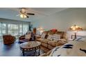 Comfortable living room with neutral colors, ceiling fan, and sliding glass doors to the outside at 225 Country Club Dr # 1104, Largo, FL 33771