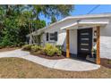 Inviting home entrance with modern black door, new landscaping, and a welcoming walkway at 331 Barbara Cir, Belleair, FL 33756