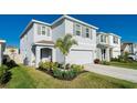 Two-story home featuring a two-car garage, neutral paint, and beautiful curb appeal at 5571 Birch River Trl, Wesley Chapel, FL 33545