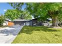 Charming single story home with a well-manicured lawn and mature trees at 5907 Tampa Shores Blvd, Tampa, FL 33615