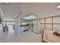 Bright kitchen featuring a skylight, white appliances, tile flooring, and a cozy adjacent dining area at 6123 113Th St # 510, Seminole, FL 33772