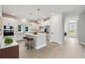 Bright, open kitchen boasts an island with seating and modern stainless steel appliances at 671 Allora Ave, Nokomis, FL 34275